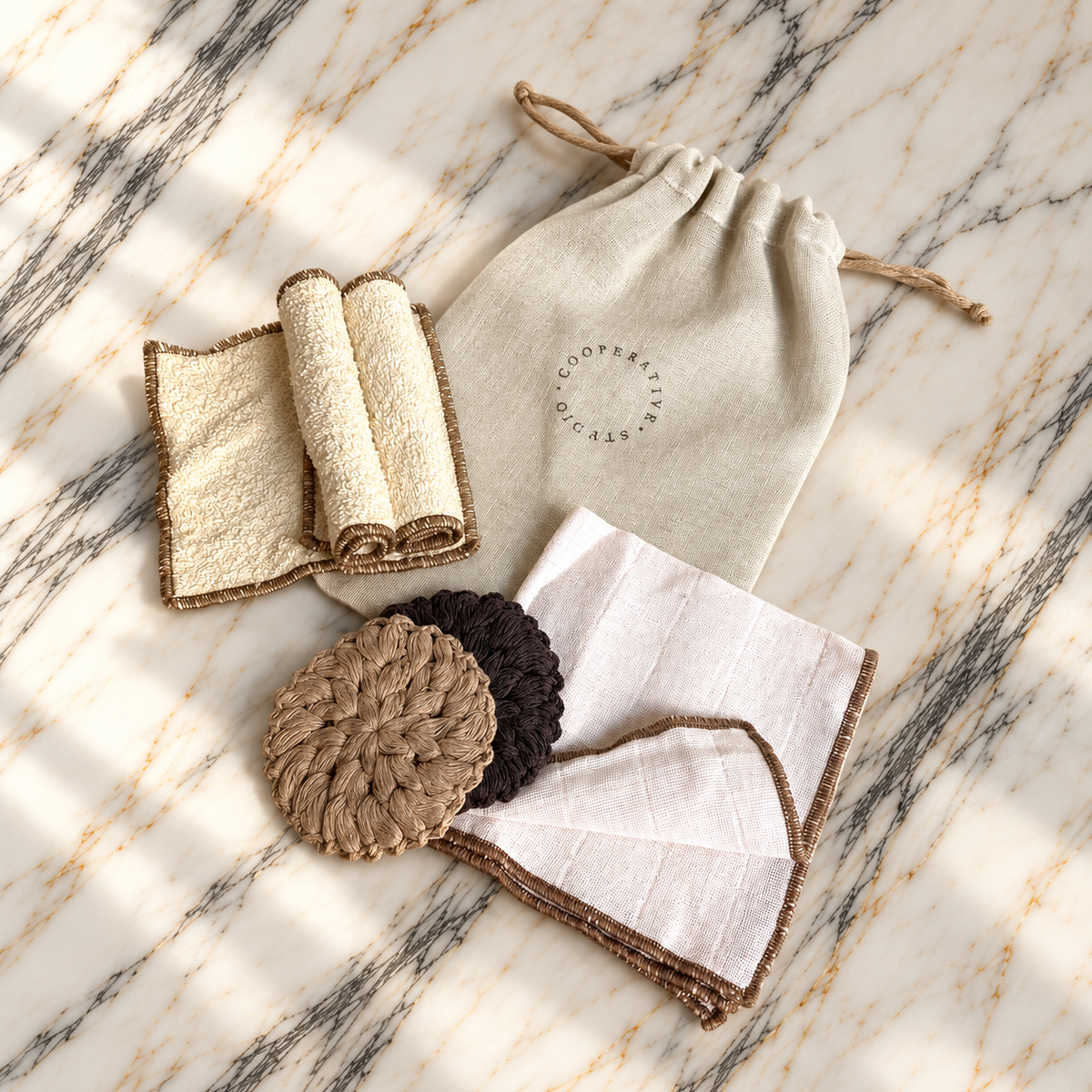 Ritual Hamam I Essential: pamuk havlu, muslin bez ve el örgüsü temizleme disklerinin mermer üzerindeki detay görünümü; kişisel bakım için özel hediye.